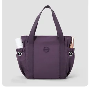 Detailed view of the nylon tote bag showing side pockets, durable handles, and spacious design.