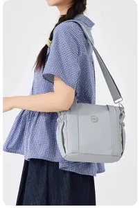 Detailed view of casual gray nylon shoulder bag with sturdy handles and adjustable strap.