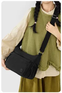 Close-up of the black nylon crossbody bag showcasing multiple functional pockets and durable strap.