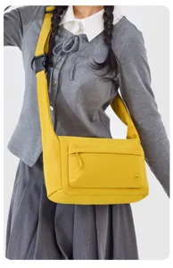 Bolso bandolera amarillo informal con correa ancha y bolsillo frontal práctico para viajes.