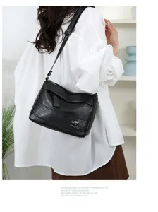 Detailed view of black soft leather crossbody bag worn by model, showing large capacity texture.