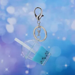 Close up view of cute blue bubble tea cup keychain with silver metal clasp and ring.