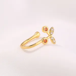 Squisito piercing naso a ciliegia dorato con pietre di zircone arancioni e brillanti bianche.