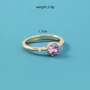 Gedetailleerde close-up van de vergulde ring versierd met een prachtige paarse zirkonia.
