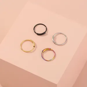 Detailopname van minimalistische veelkleurige creolen in zwart, zilver, goud en regenboogtinten.