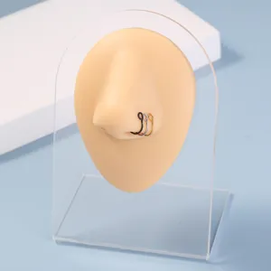 Gedetailleerd overzicht van minimalistische neusring en oorring set in zwart, zilver en goud.