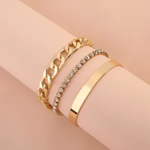 Primer plano detallado del conjunto de pulseras doradas multicapa con cadena y estrases.
