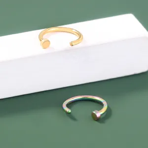 Detailopname van stijlvolle minimalistische open piercingringen in goud en regenboogkleuren.