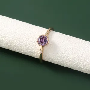 Gedetailleerde close-up van de elegante gouden paarse zirkonring met fijne steendetails.