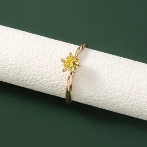Prachtige gele zirkonia ring met gedraaide gouden band detail. Elegant en stijlvol sieraad.