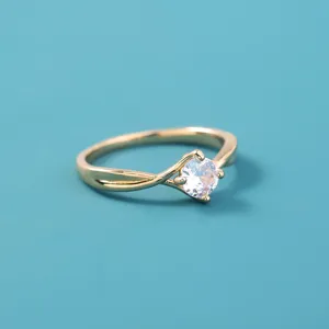 Elegante goudkleurige metalen ring met een sprankelende zirkonia steen als prachtig detail.