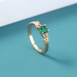 Gedetailleerd overzicht van de elegante vergulde ring met stralende groene zirkoniasteen.