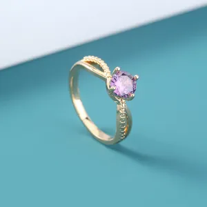 Exquise detail van de gouden paarse zircone ring met ingewikkelde gedraaide band.