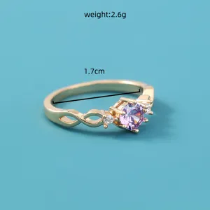 Gedetailleerde close-up van een vergulde gedraaide ring met een prachtige paarse zirkonia.