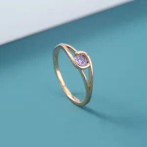 Elegante goudkleurige ring met sprankelende paarse zirkonia in een modern uniek ontwerp.