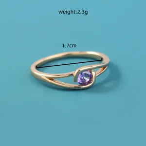 Gedetailleerde close-up van gouden metalen ring met paarse zirkoonsteen en maatspecificatie.