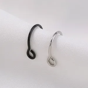 Detailopname van minimalisten metalen piercingringen in zwart en zilverkleurig.