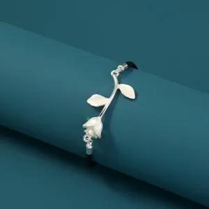 Exquisites silbernes Rosen-Armband mit schwarzer Kordel, ein elegantes Trend-Detail.