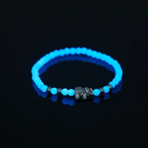 Leuchtendes Perlenarmband mit dunklem Elefanten-Anhänger, blaues Modeaccessoire.