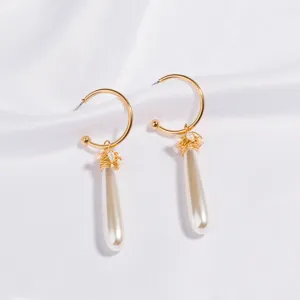 Chic gold hoop earrings featuring handmade wire-wrapped pearls and elegant teardrop pendants.