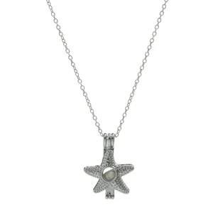 Close-up detail of a silver starfish locket cage pendant necklace on a clean white background.