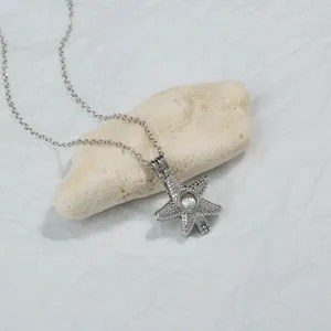 Detailed view of silver starfish pendant necklace on stone background, elegant jewelry accessory.