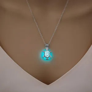 Nahaufnahme einer silberfarbenen Hohl-Schildkröten-Halskette mit einem leuchtend blauen Kern.