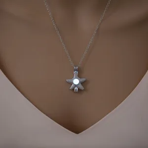 Silver starfish cage pendant necklace with glowing bead accessory for women daily fashion wear.