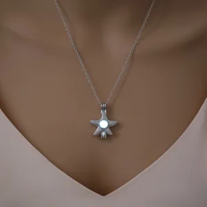 Close-up detail of the silver-toned starfish pendant featuring a luminous center bead.