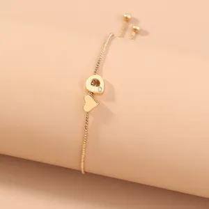 Gold adjustable letter bracelet detail shot showing heart and alphabet charm on delicate box chain.