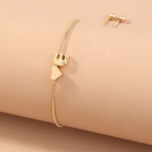 Close-up of elegant gold adjustable slider bracelet with cute elephant and heart charm.