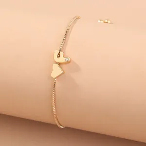 Gold adjustable box chain bracelet with heart charms and sparkling rhinestone detail stylish.