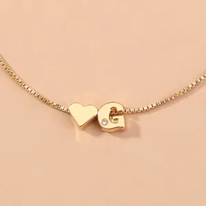 Gold box chain detail view featuring a cute heart charm and letter G pendant with crystal.