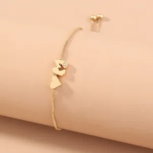 Close up view of the gold initial letter M heart charm adjustable box chain bracelet detail.