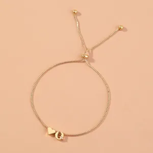 Gold adjustable box chain bracelet with heart and letter Q charms, detailed view of copper jewelry.