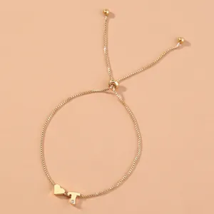 Gold adjustable box chain bracelet detail, minimalist heart charm and rhinestone letter T.