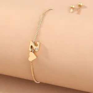Gold letter N and heart pendant bracelet detail shot showing the delicate box chain design