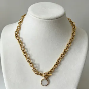 Collar de cadena gruesa de acero dorado con colgante blanco y elegante cierre de barra T.
