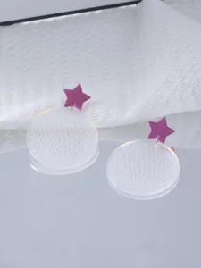 Close-up detail shot of acrylic purple star and laser disco ball earrings, trendy design.