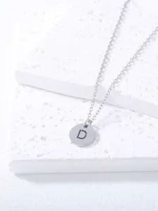 Detailed close-up of a minimalist stainless steel clavicle chain with a round letter D pendant.