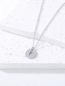 Stainless steel initial letter F pendant necklace close up detail shot showing texture.