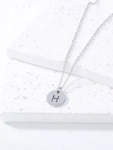 Stainless steel letter H pendant necklace detail shot, minimalist jewelry design close-up view.