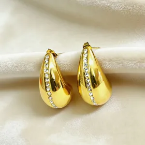 Detail close-up of 18k gold plated titanium steel teardrop rhinestone earrings, luxury design.