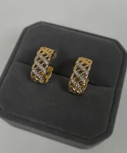Gros plan détaillé de boucles d'oreilles créoles dorées élégantes avec des strass.