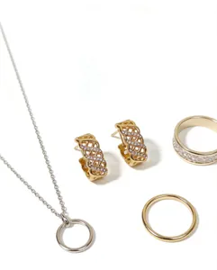 Vue détaillée de l'ensemble de bijoux tendance avec collier, boucles d'oreilles et bagues chic.