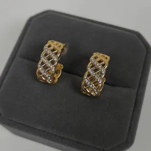 Boucles d'oreilles créoles dorées à motif ajouré, ornées de zirconiums étincelants chic.