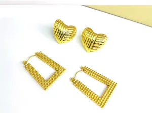 Set de pendientes de acero inoxidable dorado con tachuelas de corazón y aros geométricos.