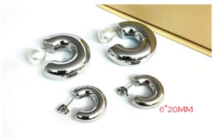 Detail view of stylish stainless steel C-shaped pearl hoop earrings in silver finish.