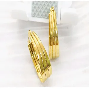 Detailed close-up of wide gold-plated multi-strand U-shaped hoop earrings, fashion jewelry.