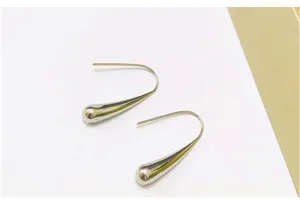 Close-up detail shot of elegant silver metal teardrop hook earrings with polished finish.